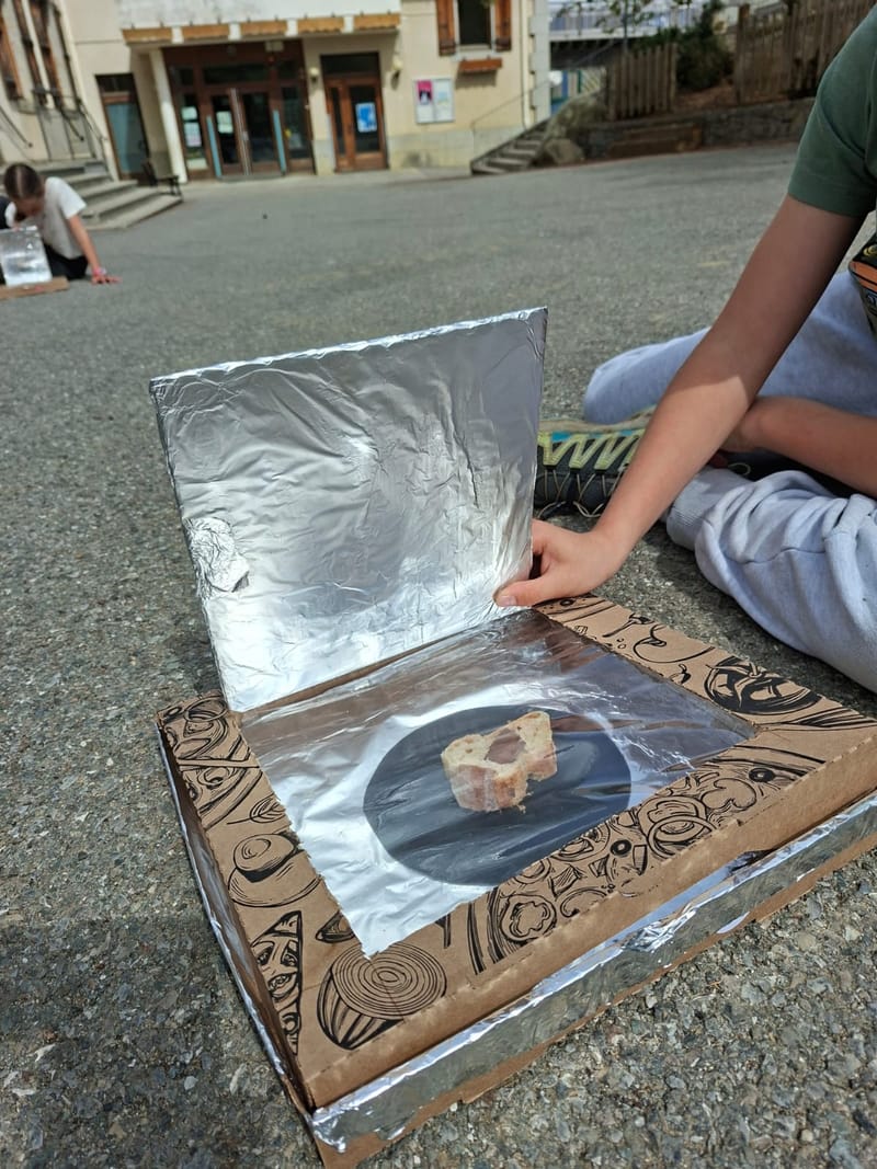 Four solaire fabriqué dans un carton à pizza, avec du pain qui chauffe