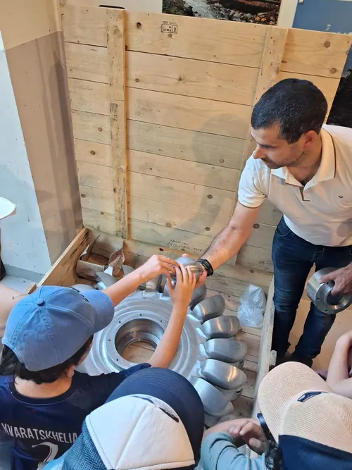 Enfants découvrant une roue de turbine hydroélectrique